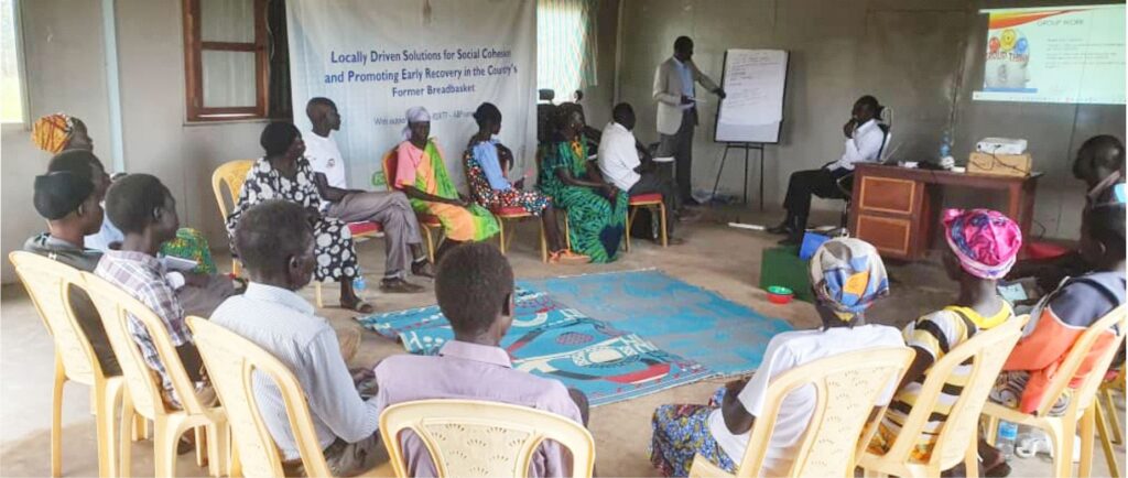 Community members including women, men and youth in peacebuilding meeting